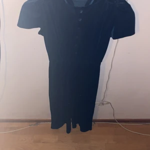 Suit - Tyget är mjuk den är blå jätte mörk blå eller grön det är olika vad man kolla på och den har fluffiga knappar och bakom har det typ som en liten grej