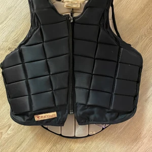 Ridväst - Säljer en fin ridväst köpt för ca 2000kr. Det är lite defekter på in sidan men de syns inget på utsidan. Kom privat för fler bilder. Storlek en är L i barn storlek skulle säga att den passar xxs-xs