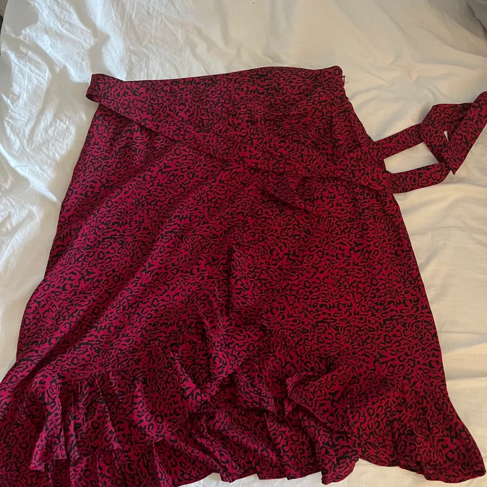 Röd leopard kjol från AMELIE & ME. Kjolen är tunn och luftig. Jättefin på sommaren när man är lite brun. den har ett snöre runt midjan så man kan knyta hur tajt man vill ha den. Säljer pga den är för stor 🥺 frakt+köp❤️. Kjolar.