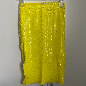Paljettkjol - Gul paljettkjol som slutar strax nedanför knäna på mig som är 165cm. Kjolen är i strl S och från Ivy Revel. Perfekt att klä upp till ett festligt tillfälle men också klä ner till vardags. Den får allas humör att stiga! 