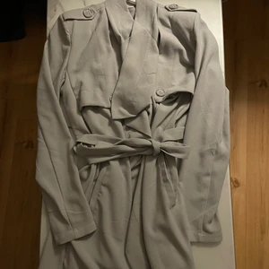 Trenchcoat - Blå/grå trenchcoat i stl s. Använd men i nyskick, dvs inget att anmärka på. 80kr exkl frakt. Samfraktar vid köp av flera plagg!🌸🌸