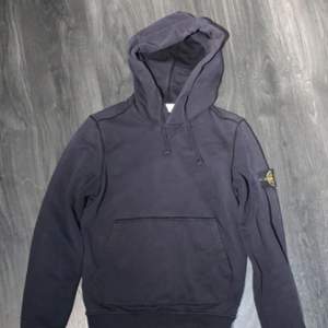 Säljer stone island mörkblå hoodie storlek S.                                              Skick 8/10 och det är bara att skriva för att få qr kåd