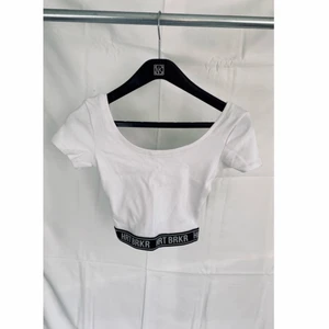 Croptop HRTBRKR - Snygg vit croptop med text ”HRT BRK” längst midjan. Inköpt på Bershka, storlek XS