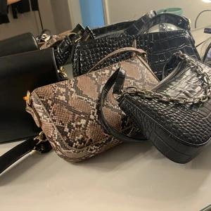 Säljer dessa 4 väskor. Aldrig använt. - Helt nytt skick. Ganska rymliga. Axelväskor. Skinn utan kedja och ormskinn 50-40 kr styck. Svart skinnväska med guld detalj 80 kr. Svart med silver detalj 100 kr