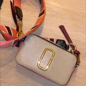 Beige/rosa Marc Jacobs väska med gulddetaljer. Äkta. Köpt 2018, använt skick. Kan skicka spårbart om så önskas. Köpare står för frakt! 