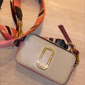 Marc Jacobs väska  - Beige/rosa Marc Jacobs väska med gulddetaljer. Äkta. Köpt 2018, använt skick. Kan skicka spårbart om så önskas. Köpare står för frakt! 