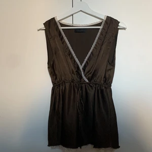 Brunt spetslinne  - Så gulligt brunt linne från Vero Moda med en varm vit spetskant samt justerbar midja. Är i storlek L men passar även en M utmärkt. Nyskick. 