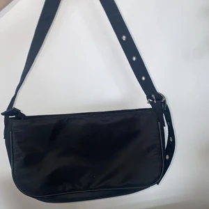 Väska  - Cool och trendig väska som man dessutom kan spänna in bandet på! 