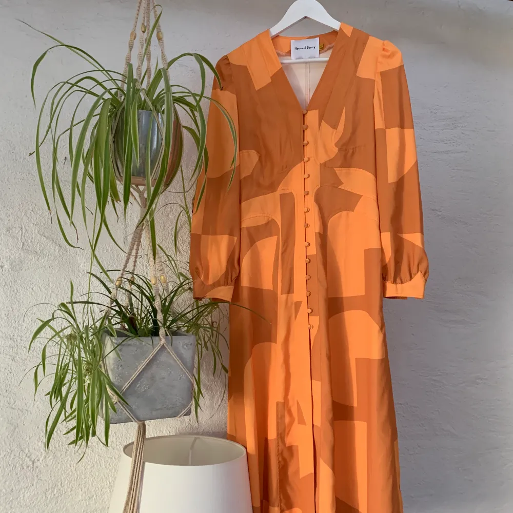 En orange mönstrad klänning från House of Sunny i strl 36. Skit snygg men har aldrig kommit till användning av mig. OBS: defekt i form av repa i tyg se bild 3, syns bara på  mycket nära håll.🧡. Klänningar.
