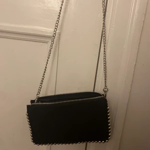Zara väska!!❤️ - Superfin Zara väska i svart lite skimrande tyg, pärlor runt om, band som lätt kan bytas ut och super bra förvaring. Får plats med en mobil och lite till (ungefär 18cm) Användts cirka 7 ggr och inga defekter. Köpt på Zara Stureplan för 229kr. Köparen står för frankt men pris kan diskuteras💞 