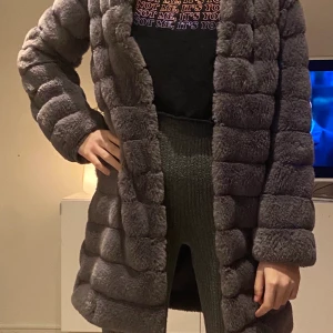 Grå kappa i fuskpäls - Obefintligt oanvänd kappa i fuskpäls från Amisu. Kappan går att knäppa. 