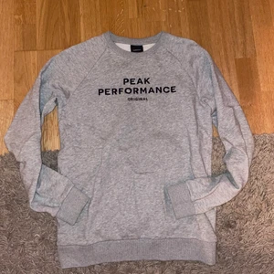 Grå Peak Performance sweatshirt  - Jätte fin och skön peak performance tröja.                                   Nypris 1000kr men säljer för 250kr.                                           Köparen står för frakt, men kan dock mötas upp i Stockholm. 