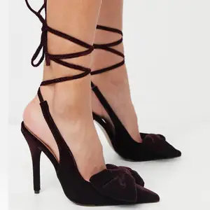 Oanvända vinröda högklackade skor med knytning runt benet och rosett