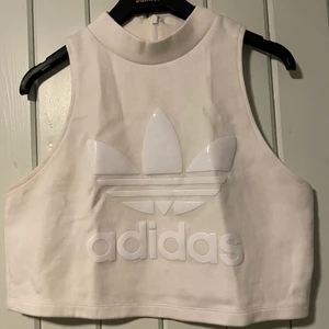 Vit adidas topp i storlek L - Vit adidas topp/magtröja med glansigt tryck i storlek L. 
