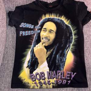 Graphic t-shirt med färgat tryck på framsidan och svartvitt på baksidan av Bob Marley. Storlek S dam men passar bra på XS också. Märket är Thunder. Superbra skick. Köpare står för frakt. Pm för mer info! <3 