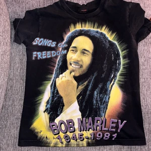 bob marley t-shirt - Graphic t-shirt med färgat tryck på framsidan och svartvitt på baksidan av Bob Marley. Storlek S dam men passar bra på XS också. Märket är Thunder. Superbra skick. Köpare står för frakt. Pm för mer info! <3 