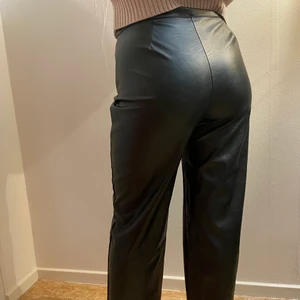 Läderbyxor, läderimitation  - Stilrena läderbyxor (läderimitation). Svarta, dragkedjan är på sidan. Storlek M