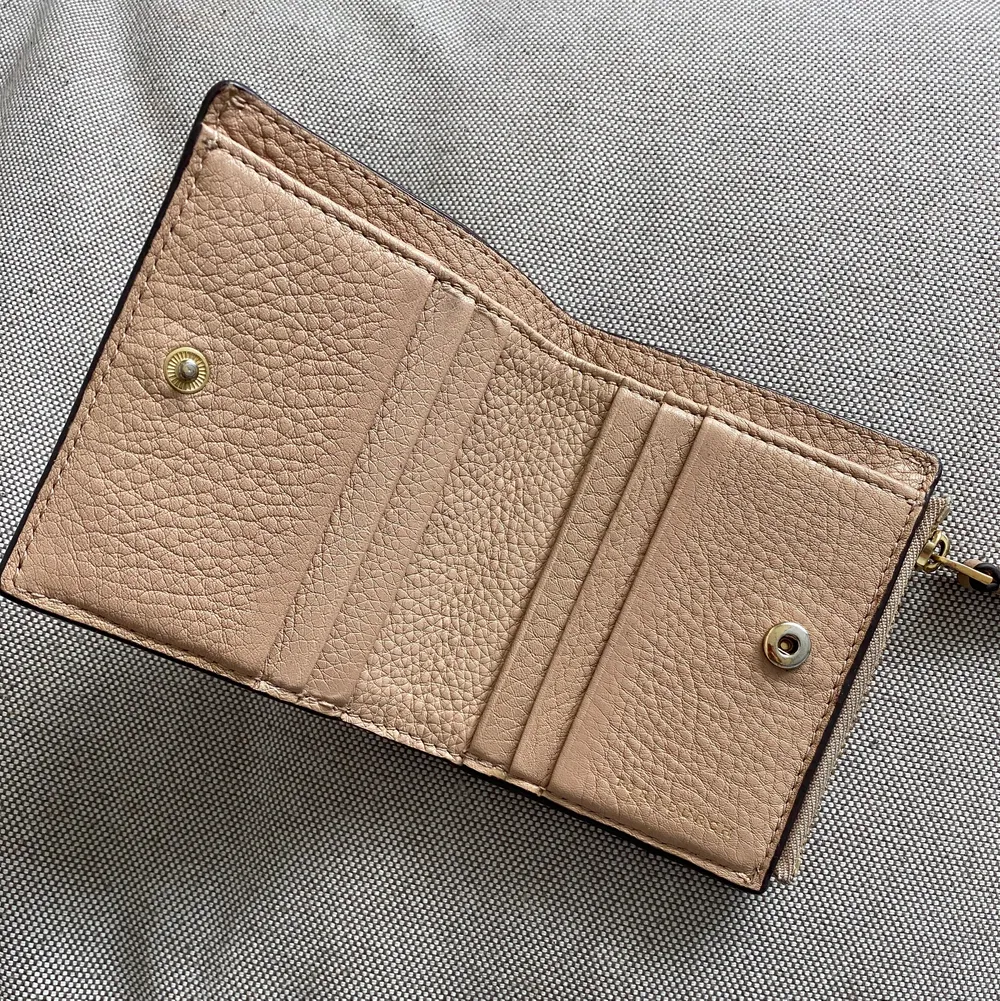 Tiramisu eller brun plånbok från Tory Burch.  Det finns 6 kortplatser, 2 inre utrymmen och en mynthållare.  lite smutsig på baksidan.. Väskor.