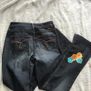 bootcut jeans med blommor - Ett par supersöt och trendiga bootcut jeans från Esprit/denim. Jeansen är i superbra kvalitet och har små påstryka blommor nertill. De är i storlek 36. Pris EJ inkl frakt💞