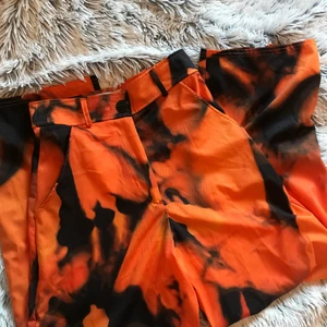 Byxor  - Skitsnygga eld mönstrade byxor. Använda 1 gång. Högmidjade med fickor. 