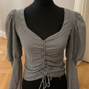 Top - Top med dragsko och puffärmar. 