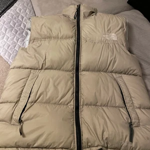 The North Face - Beige dunväst från North Face i storlek XL. Väldigt fint skick, som ny! 1000 kr eller högst budande