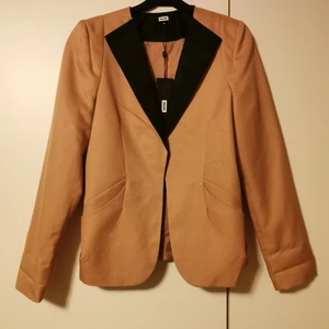 Kavaj - Jättefin ljus, lite rostig rosa kavaj med svarta detaljer. Helt ny med lapp kvar från bikbok, storlek M. Fickor och knäpps med hyska och hake. Ärmarna är släta, men den har hängt med uppvikta ärmar i garderoben😅 Nypris 399:- Köparen står för frakten, men vet inte exakt kostnad nu. 