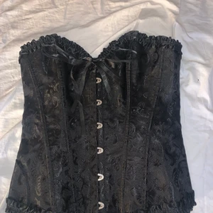 Svart corset - Säljer min helt oanvända corset som jag köpte från ROMWE för snitt ett halvår sedan men alldrig använt pga att den inte passa. Skriv privat för fler bilder :)