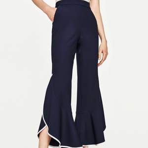 Zara mörkblåa byxor med hög midja och volang i kontrast. Material är jättebra kvalitet. Använd en gång och ser ut som nya. Storlek M. 