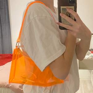 Neon orange genomskinlig väska. Helt oanvänd. Väldigt somrig och perfekt storlek. Säljer 100kr+ frakt