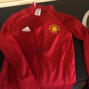 Sällan använd röd sweatshirt med zip från Adidas samt tryck med fotbollslaget Manchester United, Storlek 164