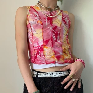 Vintage rosa orange blommigt mesh linne - Blommigt vintage stretchigt patchwork mesh linne i mörk- och ljusrosa, orange, gul och vit med vitt underlinne och lettuce hem🌺 Jag älskar att designen på linnet påminner om siluetten av en korsett fast utan det stela och obekväma! Färgerna passar så bra ihop och är tillräckligt starka för att para till ett par ljusa linnebyxor, göra en kontrast med ett par mörka kostymbyxor, ett par vanliga jeans för en casual look eller gå all in med ett par byxor i lika färg! 