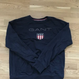  Marinblå Gant sweatshirt  - Knappt använd Gant sweatshirt i storlek 170cm(15 år) jag skulle säga att den är en S i vuxen storlek, fint skick inga synliga fläckar men ett litet hål på baksidan som knappt syns,