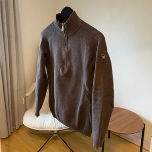 Sail Racing kragtröja - En kragtröja från Sailracing. Tröjan har en half zip dragkedja. Den är en mörkare grå i färgen och storleken är XS. I övrigt är tröjan i bra skick och säljs pga att den inte längre används.