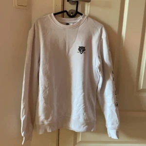 Sweatshirt - Vit sweatshirt ifrån H&M med svarta tryck på bröstet, ryggen och ena armen. Storlek XS herr. 40kr. (Köparen står för frakten) 