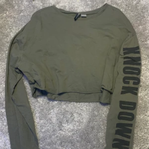 Croppad tröja  - Bommulströja, croppad. Står ”knock down” på ena armen. 