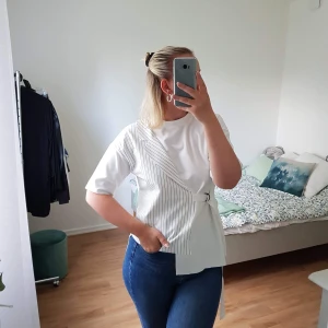 YESSTYLE T-SHIRT  - Unik T-shirt med halv skjorta detalj & reglerbart spänne i sidan. ALDRIG använd så i utmärkt skick! Ingen storlek skriven men som en S 