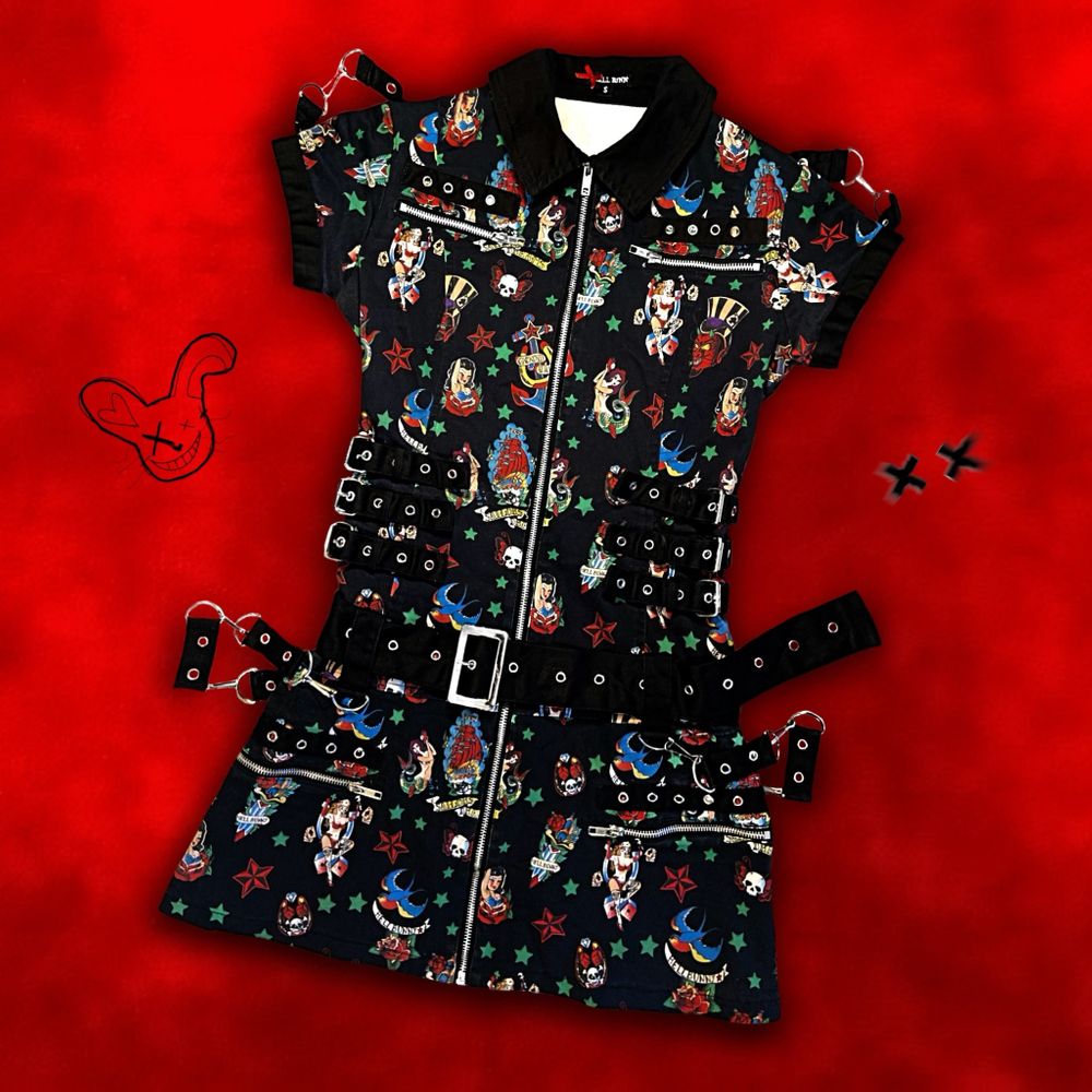 “𝑼𝒏𝒕𝒂𝒎𝒆𝒅 𝒂𝒏𝒅 𝒖𝒏𝒍𝒆𝒂𝒔𝒉𝒆𝒅.” Hey, you! Live out your wildest rockabilly dreamz i ’Rocka Bondage Dress’ från Hell Bunny🐰🔥⛓ Maxad med öljetter, kedjor, D-ringar, blixtlås, äkta fickor och avtagbara remmar fram/bak 🖤 Med snyggt 50’s inspirerat rockabilly motiv 👌🏻 Storlek S men kan göras tajtare eller lösare med sidospännena/bältet (midjemått 64-80cm och totallängd 76cm); supersnygg passform är lovad oavsett!! 📏✨ Certified deadstock! ⚰️ Inköpt 2011 för ca 860kr. Jag är 160cm. Frakt tillkommer på 66kr 💌. Klänningar.