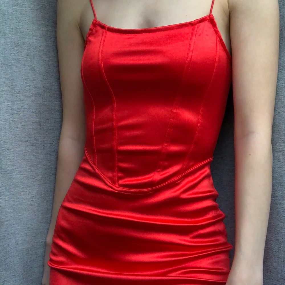 En klänning i röd glänsande satin med korsett detaljer. Kort och tight form. Storlek XS. Från H&M. Helt oanvänd! Leverans 62 kr eller mötas i Malmö. #detaljer #hm #röd #satin #klänning #korsett. Klänningar.
