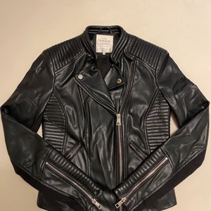 Skinnjacka från Zara - Svart skinnjacka från Zara. Har en fin passform och passar bra till sommaren. Går också att ha med kofta under. Har använts 1 gång innan och sälja eftersom den inte passar längre. 