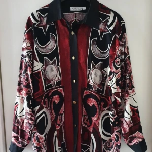 Vintage blus - Vintage blus med solar, månar och stjärnor på i storlek L. Fraktkostnad blir 66kr.