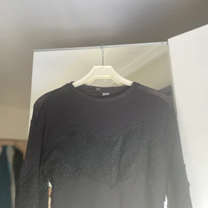 Tröja med spets - En svart långärmad tunn tröja från H&M med spets detaljer över bröstet och armarna. Köpt secondhand men aldrig använt den själv. Storlek XS