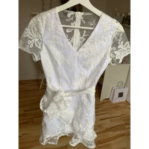 Vit mönstrad klänning - Säljer min systers vackra studentklänning 🍾 Den är endast använd en gång så den är i väldigt fint skick. Klänningen är i storlek xs. Bandet hjälper till att framhäva midjan och klänningen stängs med en dragkedja i ryggen. Det fina blommönstret gör klänningen perfekt för sommaren som är påväg!🌸  Är många intresserade blir det budgivning.                                                                          Frakt tillkommer 