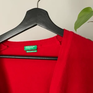 United Colors of Benetton Cardigan - Cardigan från United Colors of Benetton i jötteifnnröd färg. Köpt i butik men knappt använd, så gott som ny! Kan mötas upp i Göteborg eller frakta. 100% ull i storlek S/XS. Nypris 500