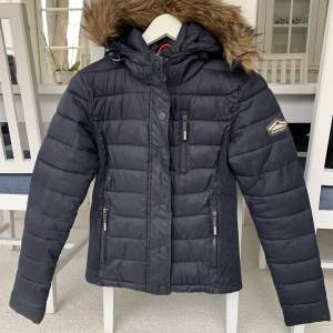 Svart Superdry Fuji jacket med fuskpälskrage, storlek Small. Jättefint skick. Nypris 1195kr.