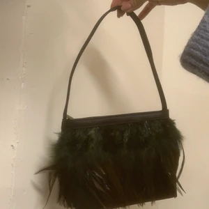 Vintage väska cosmopolitan - Super söt liten vintage väska från cosmopolitan, med gröna och svarta fjädrar! Lite mörkare färg i verkligheten❤️ möts på lidingö eööer fraktar spårbart för 66kr eller 35kr ospårbart’😍