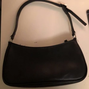 Svart handväska  - Intressekol på min fina svarta ”baguette bag” som jag säljer för minst 120 kr då jag fortfarande gillar den väldigt mycket men säljer för behöver pengarna😊väskan är i skinmattrial och är från monki. Den är använd relativt mycket men har inga synliga skador, ksk några trådar som losnat men absolut inget man tänker på💗köpare står för frakt men kan mötas up i Stockholm 💕