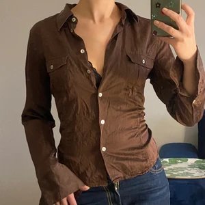 Satinskjorta från Gant - Superfin brun vintageskjorta i satineffekt från Gant. Kortare modell med längre ärmar och vita knappar. Storlek 40 men liten i storleken, passar nog 36-38 bättre.