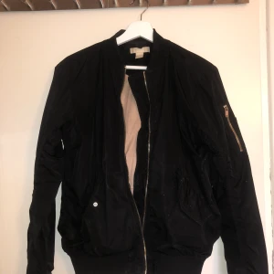 Svart bomberjacka  - Svart bomberjacka med beiget foder. Strl S