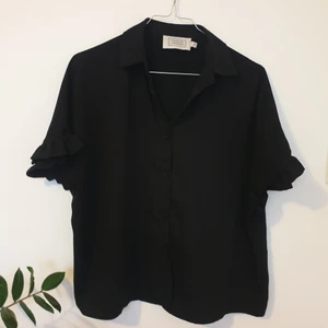 Svart Topp blus  - Svart topp/blus med knappar. Storlek 36. Den sitter lite oversized. Från NA-KD x Therese Lindgren kollektion. Kan skickas annars finns i Malmö💌